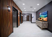 Thumbnail 30 of 31 - a hallway with elevators and a table with a painting in a lobby