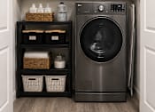 Thumbnail 10 of 33 - A black washing machine is in a cabinet with baskets and containers.