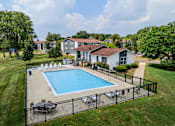Thumbnail 26 of 35 - A pool surrounded by a black fence with a house in the background.