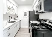 Thumbnail 3 of 21 - a kitchen with white cabinetry and black appliances  at Park On Canal Apartments, Clinton Twp, MI, 48038