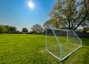 Thumbnail 20 of 21 - a soccer goal on a grassy field with trees in the background  at Park On Canal Apartments, Clinton Twp