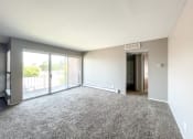 Thumbnail 9 of 35 - an empty living room with a sliding glass door and a balcony