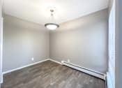 Thumbnail 16 of 35 - an empty room with hardwood floors and a light fixture