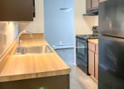 Thumbnail 15 of 35 - a kitchen with wood countertops and black appliances