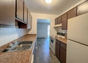 Thumbnail 6 of 35 - a kitchen with brown cabinets and a white stove top oven