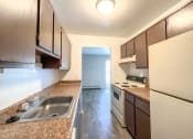 Thumbnail 14 of 35 - a kitchen with brown cabinets and a white stove top oven