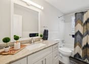 Thumbnail 27 of 45 - A bathroom with a sink, toilet, and a shower curtain.