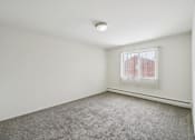 Thumbnail 35 of 45 - A room with a carpeted floor and a window with blinds.
