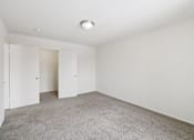 Thumbnail 37 of 45 - A large empty room with carpeted floor and white walls.