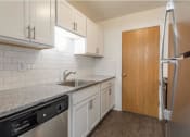 Thumbnail 15 of 25 - a kitchen with white cabinets and a black dishwasher
