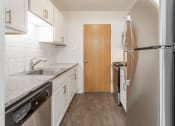 Thumbnail 16 of 25 - a small kitchen with white cabinets and stainless steel appliances
