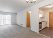 Thumbnail 19 of 25 - an empty living room with a kitchen in the background