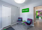 Thumbnail 7 of 25 - a room with two purple chairs and a green sign on the wall