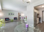 Thumbnail 9 of 25 - a living room with a glass table and chairs