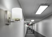 Thumbnail 73 of 73 - a long narrow hallway with lights on the wall and a carpeted floor at Troy Place Apartments - Troy, MI, Troy