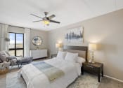 Thumbnail 38 of 73 - a bedroom with a bed and a ceiling fan at Troy Place Apartments - Troy, MI, Troy