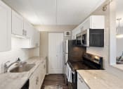 Thumbnail 18 of 73 - a kitchen with black appliances and white cabinets at Troy Place Apartments - Troy, MI, Troy, Michigan