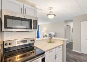 Thumbnail 26 of 73 - a kitchen with stainless steel appliances and white cabinets at Troy Place Apartments - Troy, MI, Troy