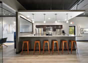 Thumbnail 60 of 73 - a kitchen with a counter and bar stools at Troy Place Apartments - Troy, MI, Troy
