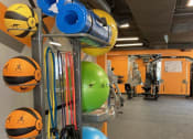 Thumbnail 53 of 73 - a collection of weights and other exercise equipment in a gym at Troy Place Apartments - Troy, MI, Troy, 48084