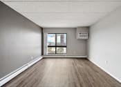 Thumbnail 35 of 73 - an empty room with a window and wood floors at Troy Place Apartments - Troy, MI, Troy, 48084