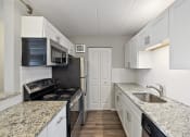 Thumbnail 15 of 73 - kitchen with white cabinets and granite counter tops at Troy Place Apartments - Troy, MI, Troy, 48084