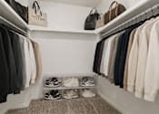 Thumbnail 24 of 31 - A white closet with clothes and shoes.