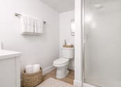 Thumbnail 18 of 31 - A white toilet sits in a bathroom next to a towel rack.