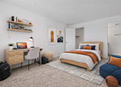 Thumbnail 23 of 31 - A bedroom with a bed, desk, and chair.