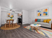 Thumbnail 4 of 26 - A living room with a grey couch, a wooden table and a rug.