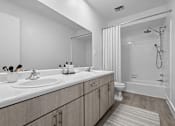 Thumbnail 16 of 38 - A bathroom with a white sink and a white tub.