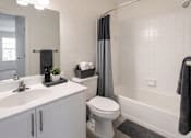 Thumbnail 14 of 24 - A white bathroom with a toilet, sink, and shower.