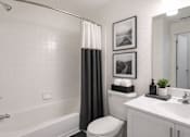 Thumbnail 15 of 24 - A white bathroom with a toilet, sink, and shower.