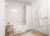 Thumbnail 17 of 31 - A white bathroom with a white towel hanging on the tub.