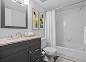 Thumbnail 9 of 26 - A bathroom with a toilet, sink, and bathtub.