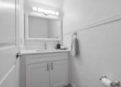 Thumbnail 11 of 14 - A bathroom with a sink, mirror, and towel rack.