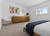 Thumbnail 21 of 38 - A bedroom with a bed, a chair, a dresser, and a window.