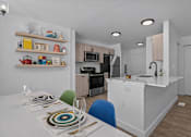 Thumbnail 2 of 38 - A modern kitchen with a dining table set for two.