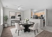 Thumbnail 18 of 87 - Dining area with round table and modern kitchen at Village Club of Farmington Hills Apartments, Farmington Hills, 48331