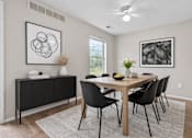 Thumbnail 29 of 87 - Dining room with wood table and black chairs at Village Club of Farmington Hills Apartments, Farmington Hills, Michigan