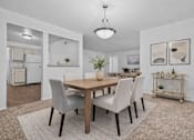 Thumbnail 11 of 47 - A dining room with a table and chairs.