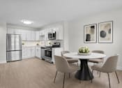 Thumbnail 2 of 14 - A modern kitchen with a dining table set for four.