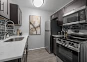 Thumbnail 14 of 33 - A modern kitchen with a stainless steel oven and microwave.