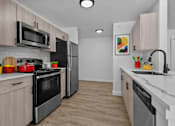 Thumbnail 1 of 38 - A kitchen with a black refrigerator and stove top oven.