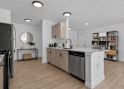 Thumbnail 3 of 38 - A modern kitchen with wooden floors and stainless steel appliances.