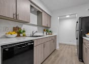 Thumbnail 10 of 38 - A kitchen with black appliances and wooden cabinets.