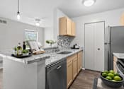 Thumbnail 16 of 87 - Kitchen with granite countertops and mosaic tile backsplash at Village Club of Farmington Hills Apartments, Michigan