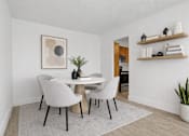 Thumbnail 13 of 31 - A dining room with a white table and grey chairs.