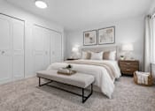 Thumbnail 23 of 38 - A bedroom with a large bed, a bench, and two nightstands.