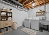 Thumbnail 29 of 47 - A laundry room with a washer and dryer, a basket, and a rug.